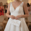 Close up of a bride holding a personalised white "Mrs Rees" wedding clutch bag at a relaxed evening reception, perfect for bridal accessories.