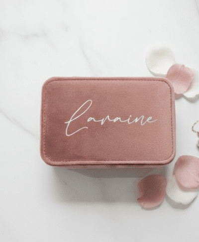 a small, rectangular travel jewellery case, closed and made of rose quartz velvet fabric. The lid is personalised with the name 